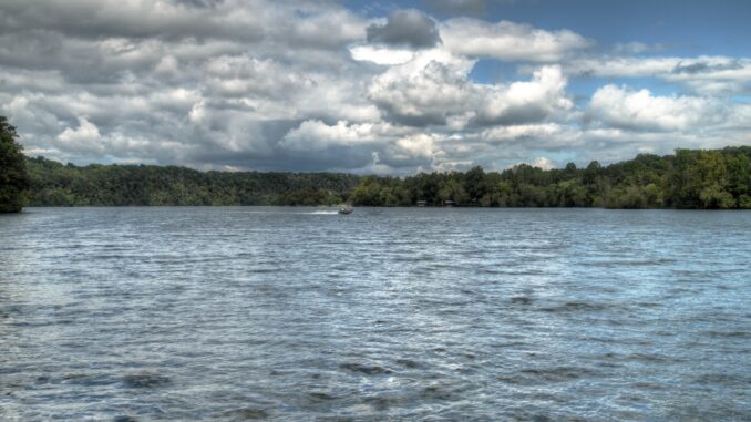 View of watts bar lake in east tennessee on cloudy day with boat in the distance on waves